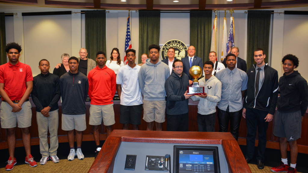 The Oldsmar Christian Soaring Eagles boys varsity basketball team poses with Oldsmar City Council members and other officials after winning the state championship.