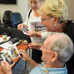 Beverland looks at some old photos with Pat Lamphear and Jeri Antozzi.