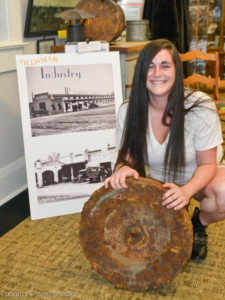 Elizabeth Lyons was recently reunited with the antique Oldsmobile flywheel she found on her property.