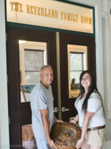 Eric Ramquist and Elizabeth Lyons carry the flywheel out of the Oldsmar Historical Society Museum on Tuesday afternoon.