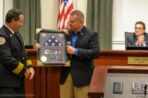 U.S. Army veteran Mark Lynn presents a flag that flew over Bagram Air Force Base in Afghanistan to Oldsmar Fire Rescue Chief Dean O'Nale while Mayor Doug Bevis watches during the Nov. 1, 2016 City Council meeting. 