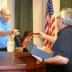 Woodcarver Ray Poynor hands a custom heart pine pen to Council member Jerry Beverland on Dec. 6, 2016.