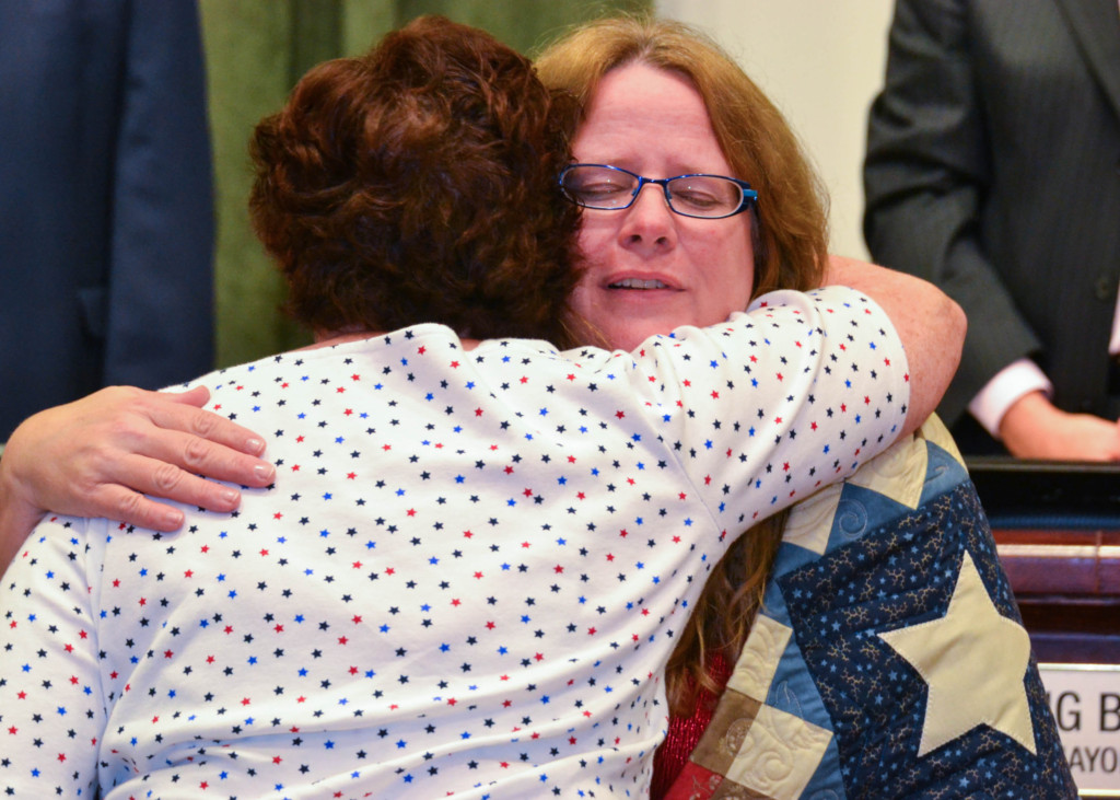 Oldsmar City Clerk Ann Nixon hugs Ginger Messer after receiving her Quilt of Valor during the Oldsmar City Council meeting on Dec. 6, 2016.